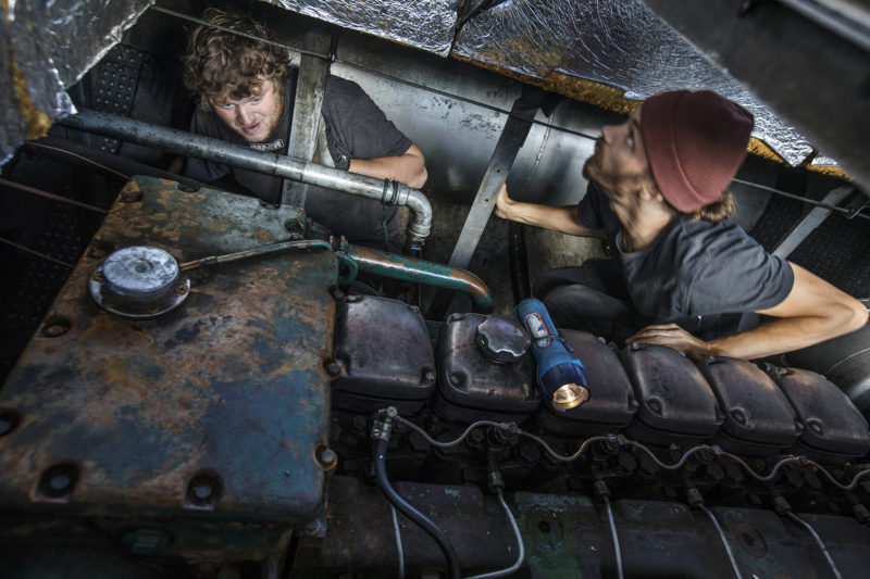 Två smutsiga personer i maskinrummet på ett fartyg.