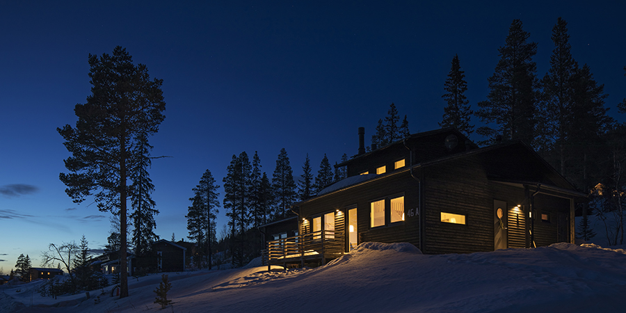 Upplyst fjällstuga i snö