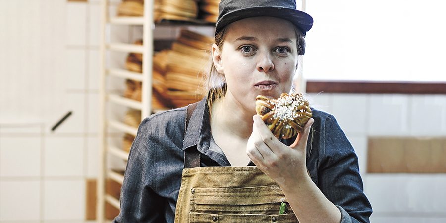 Kvinna äter en bulle i ett bageriet Majas Skafferi
