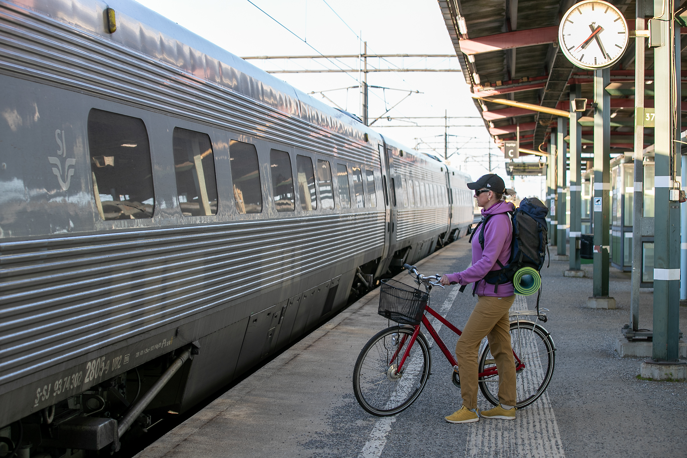 Kvinna på tågperrong med cykel