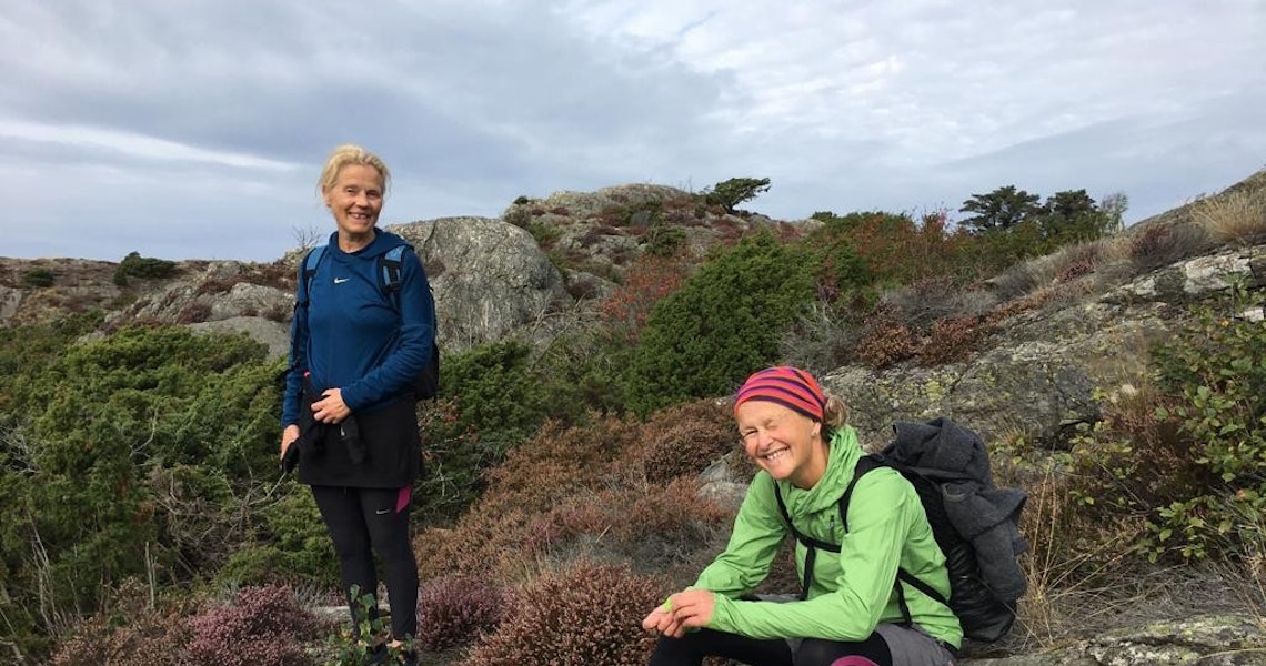 Två kvinnor i vandringskläder i bergslandskap