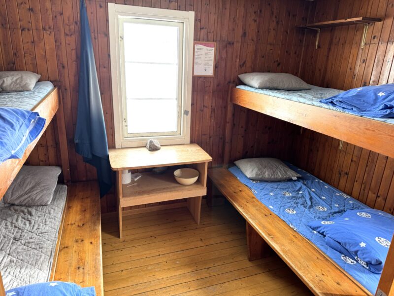 Fyra väggfasta våningssängar och ett tvättskåp i en STF-stuga.