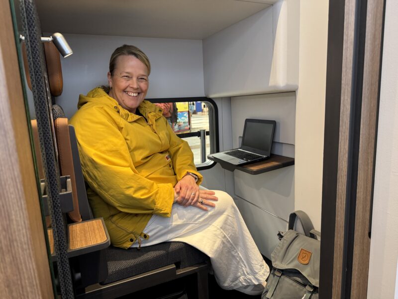 Kvinna i gul jacka sitter i en kupé i de nya nattågen.