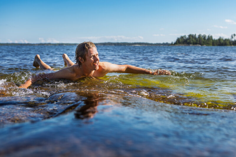 Ungman badar på kliipphäll i Stockholms skärgård