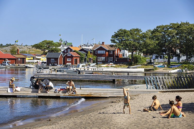 Idyllisk sandstrand och skärgårdsbebyggelse på Sandhamn i Stockholms skärgård