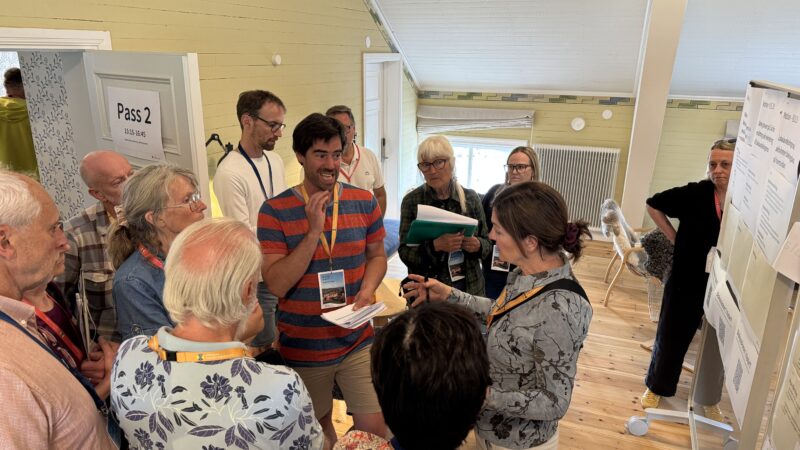 Flera människor står i en cirkel inne i en konferensanläggning.